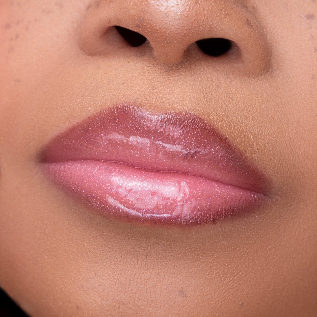 Pink Lipps She’s All That Glow Lip Oil on lips of model – high shine finish on light to medium skin tone