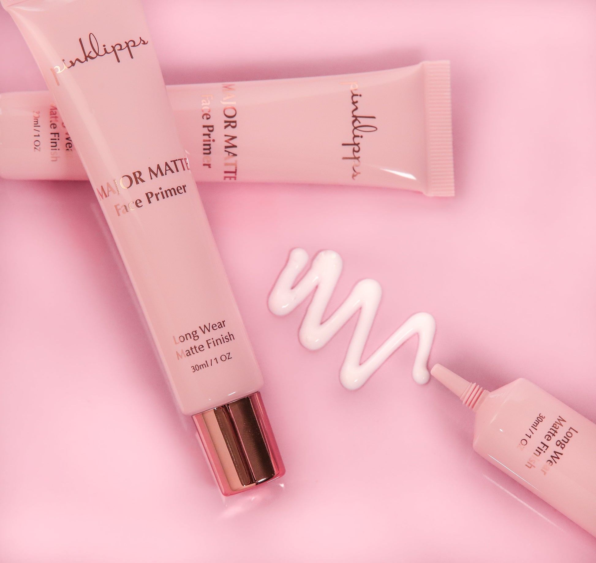 Flat-lay of Pink Lipps Major Matte Primer tube styled on pink background with rose-gold accent cap – editorial studio lighting, ‘Confidence is Beauty’ tone.