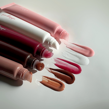 Flat lay swatch of LippEase Tinted Lip Treatments (high-shine balm) showing glassy finish on white background