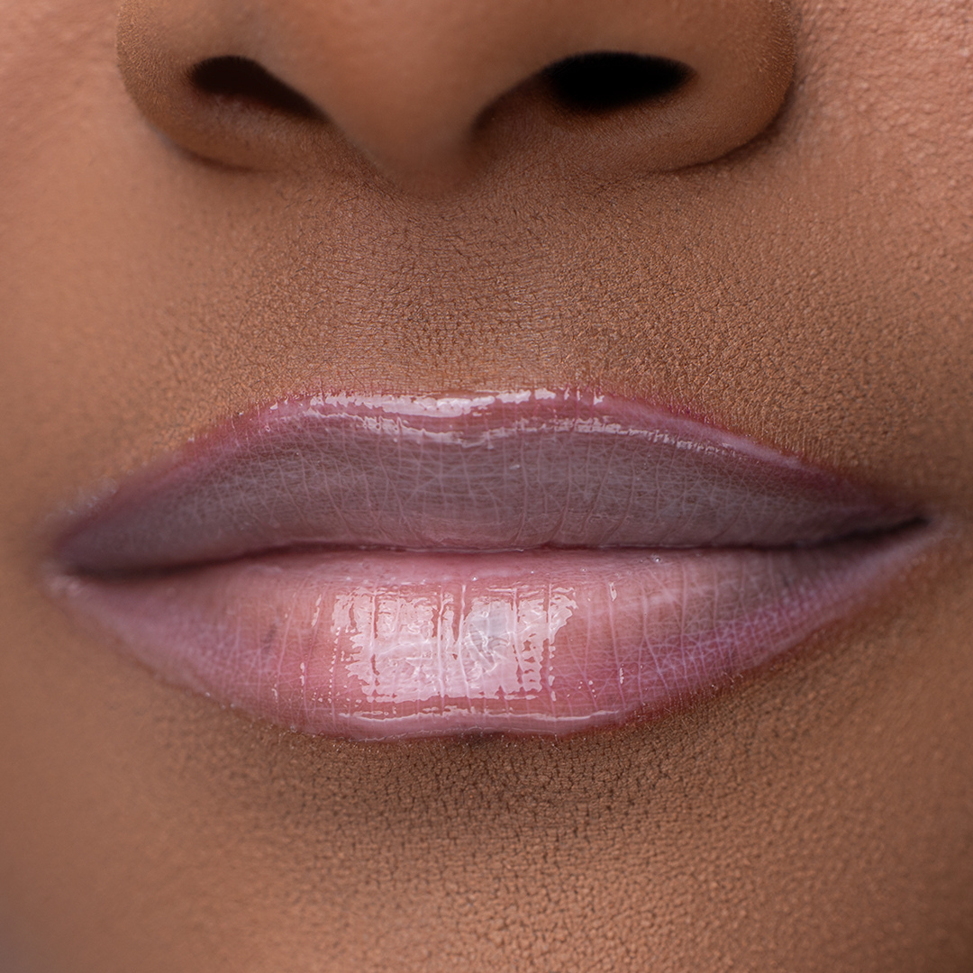 Close-up of LippEase Tinted Lip Treatments Power showing glossy pink high shine finish on medium skin tone.
