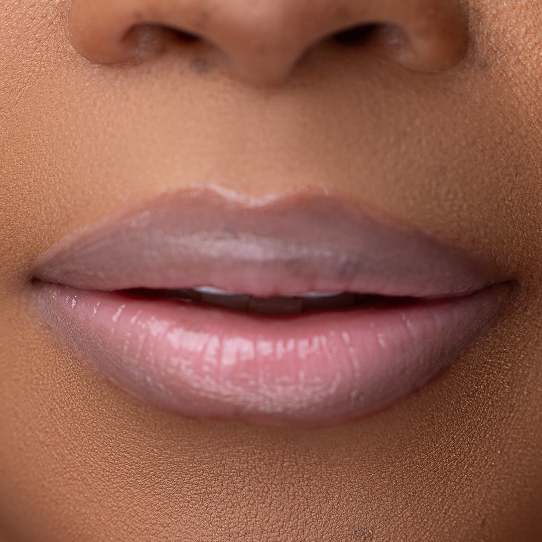 Close-up of LippEase Tinted Lip Treatments Power showing glossy pink high shine finish on light skin tone.