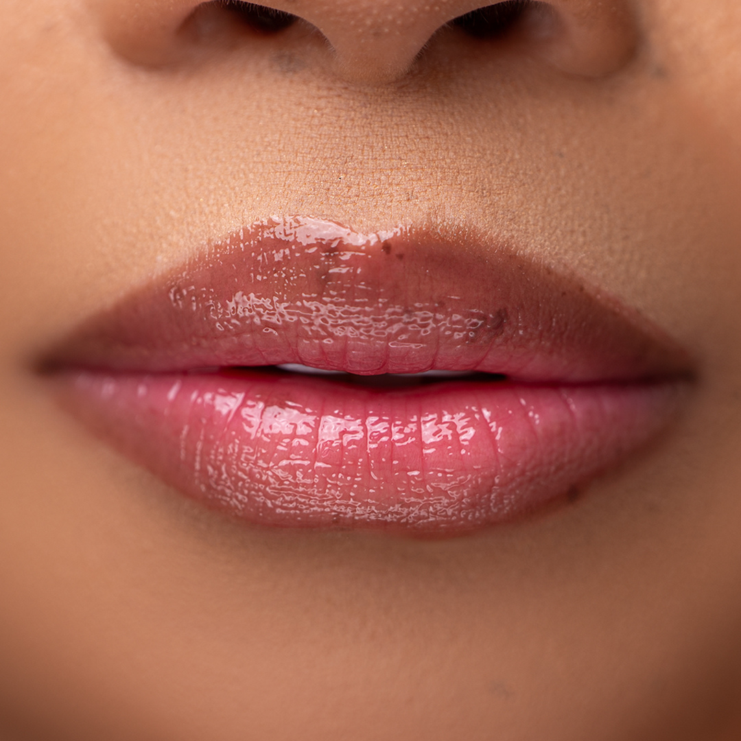 Close-up of LippEase Tinted Lip Treatments Rich showing glossy burgundy high shine finish on light skin tone.