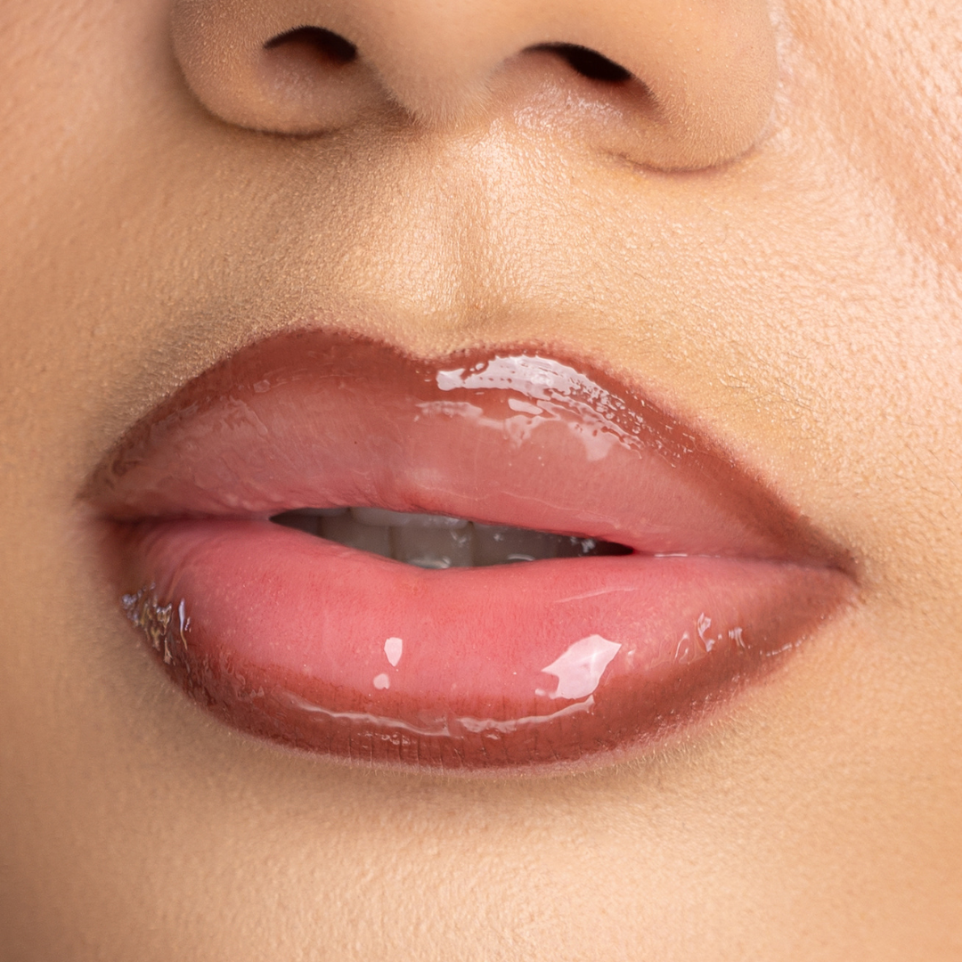 Lip-on model shot: Strip Nude Glass Gloss applied on light skin tone — pigmented high-shine finish