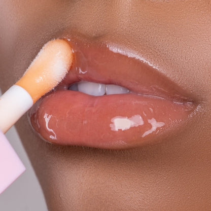 Lip model shot of orange SunGlow Glow Lip Oil applied over medium skin tone – radiant glass finish with hydrating glow.