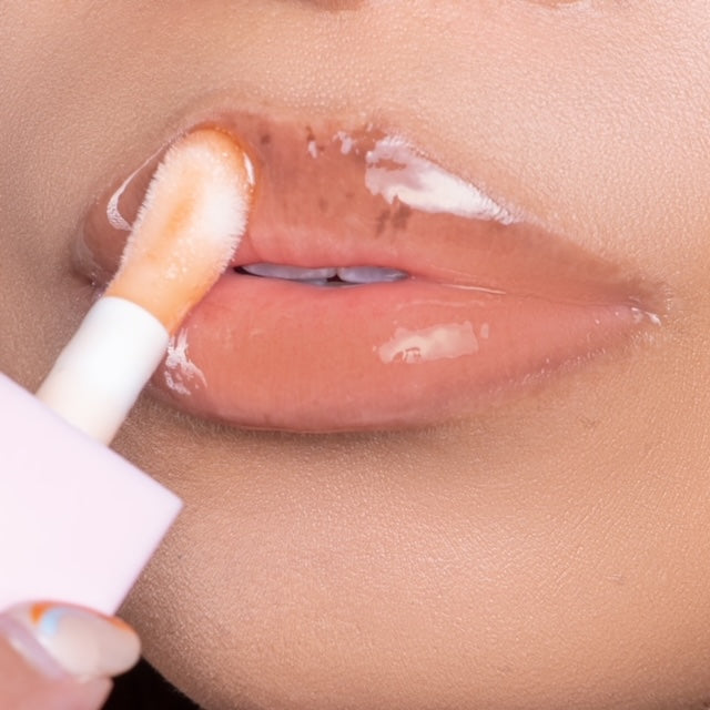 Lip model shot of orange SunGlow Glow Lip Oil applied over light skin tone – radiant glass finish with hydrating glow.